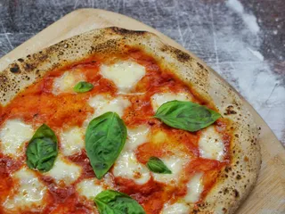 A margherita pizza with fresh basil and melted mozzarella