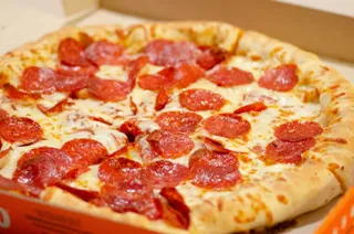 A whole pepperoni pizza in a box