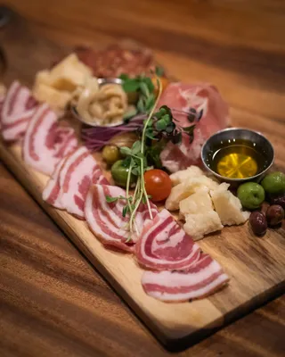 Sliced cured meats and cheese on a wooden board