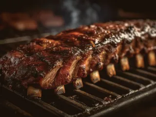 A rack of glazed pork ribs on the grill