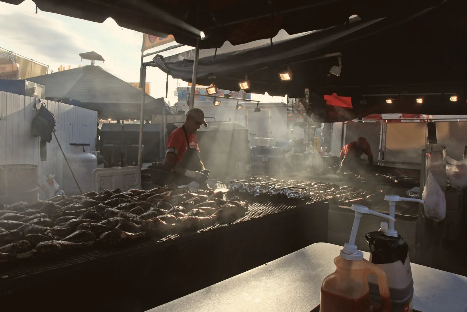 Smoke drifting over meat on an outdoor grill