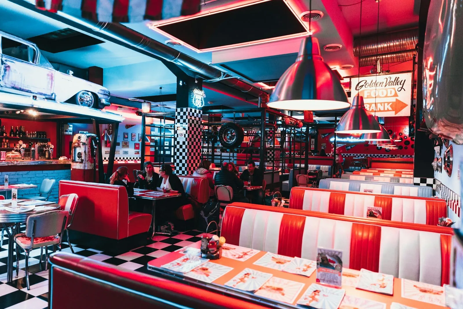 Rows of red and white booths under red pendant lights