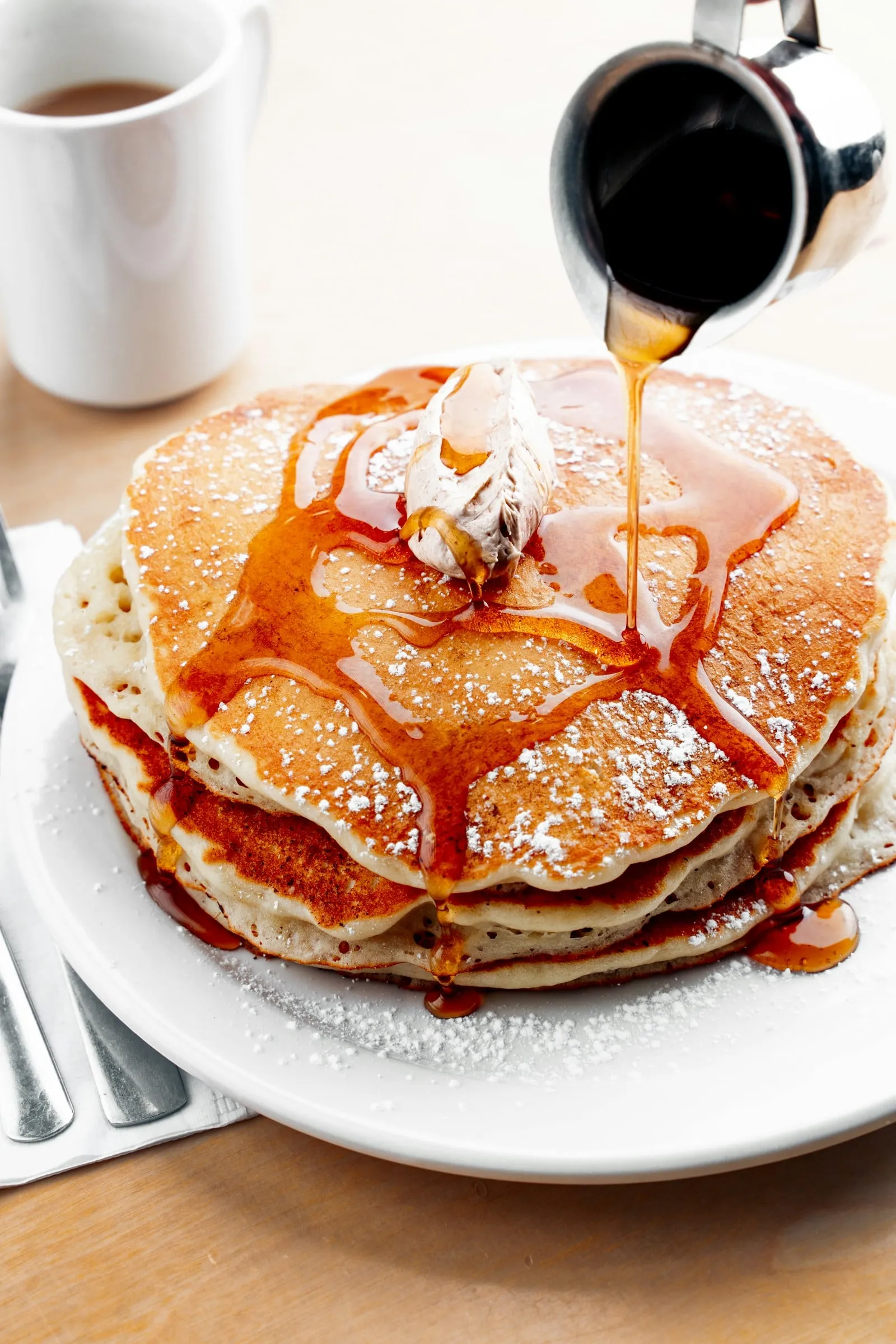 Syrup poured over a stack of pancakes
