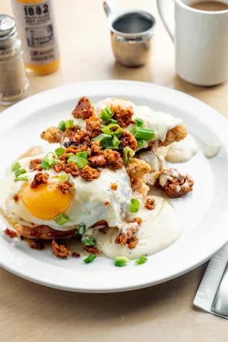 A skillet of potatoes topped with a fried egg