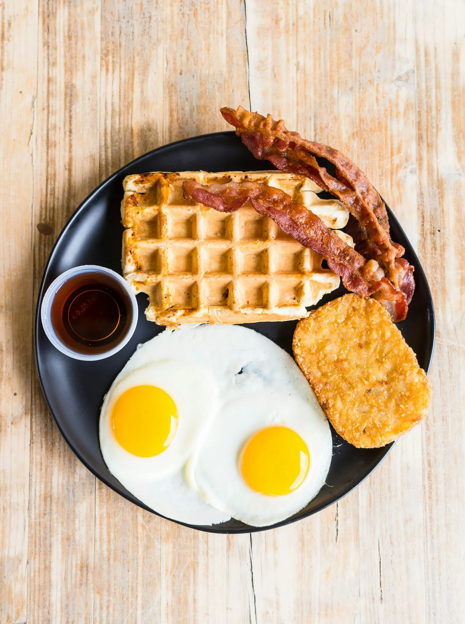 A waffle with bacon and two eggs