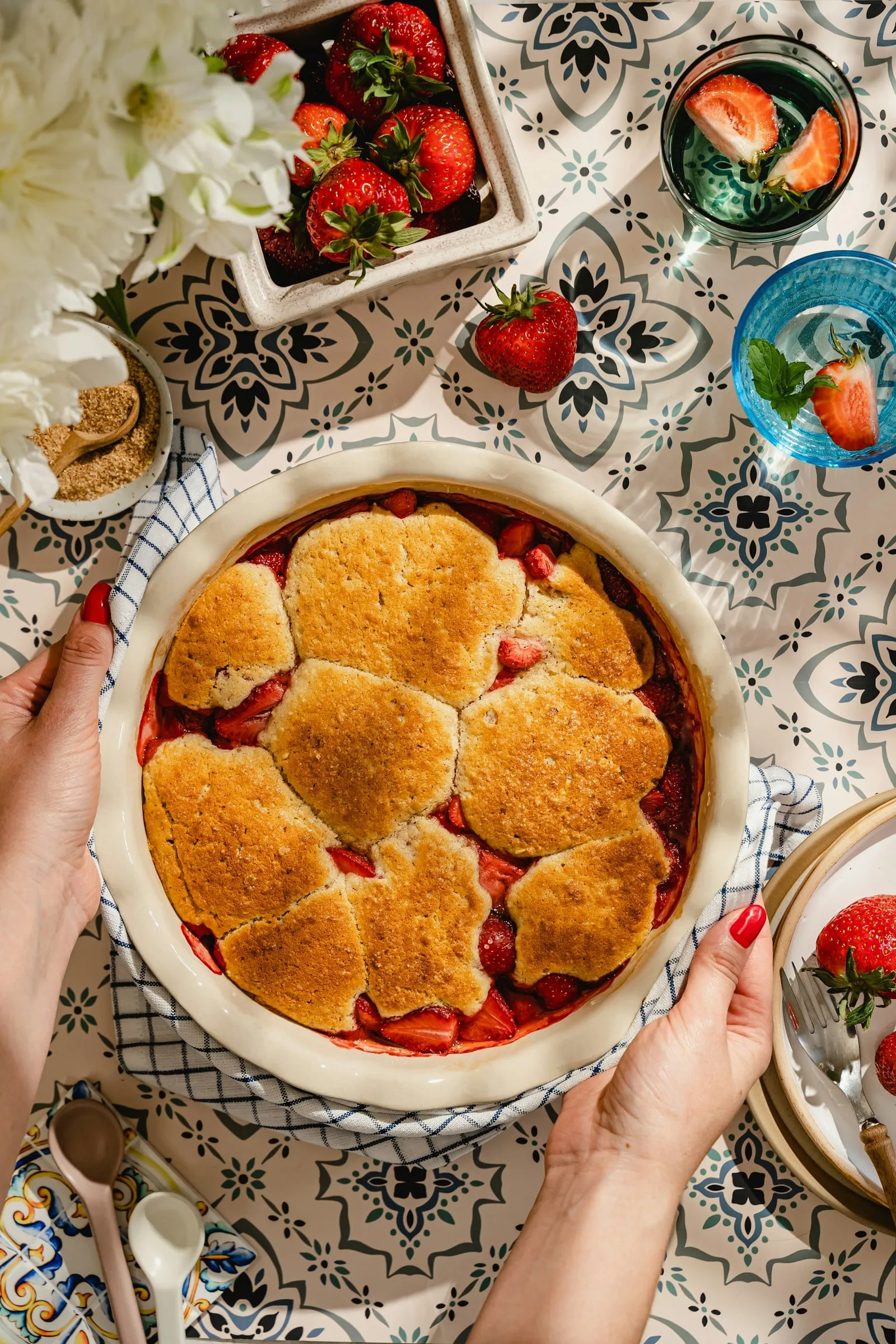 Peach cobbler with a golden biscuit crust in a round baking dish