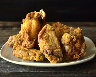 Golden fried chicken piled on a white plate