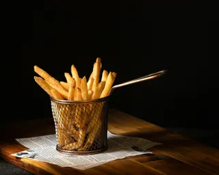 Golden french fries in a wire basket