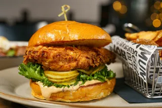 A crispy fried chicken sandwich with lettuce and pickles